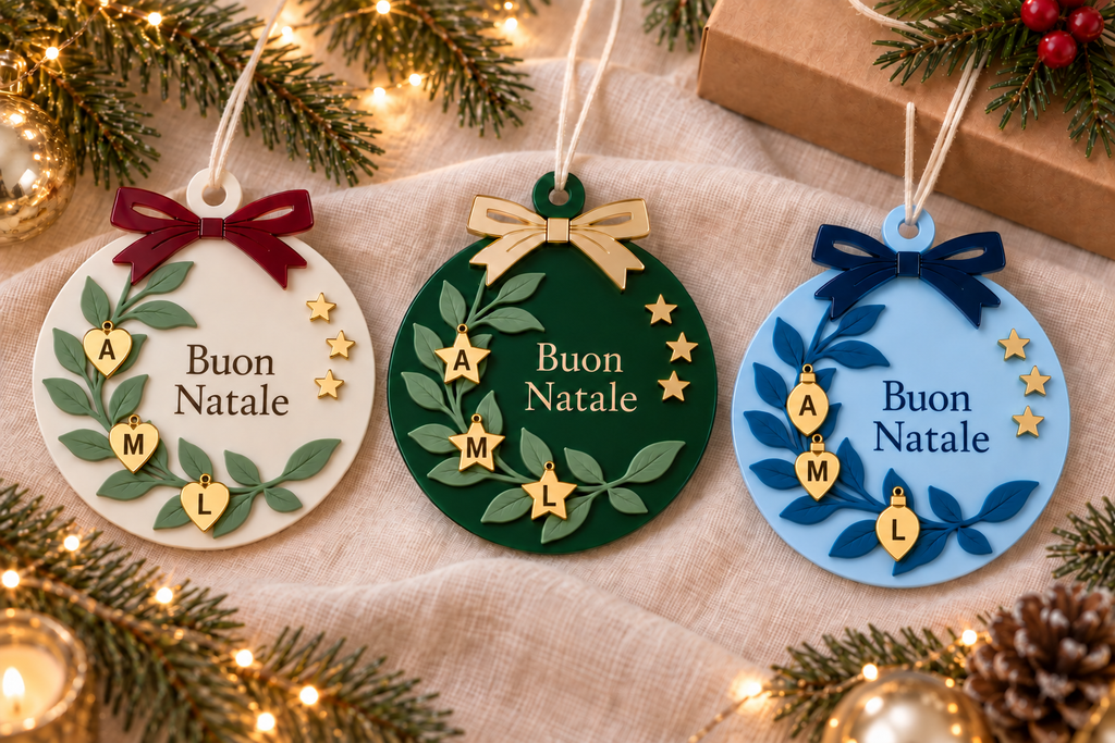 Palline Buon Natale con tre iniziali, cuori stelline e gocce oro, in tre abbinamenti colore; ambientazione illustrativa